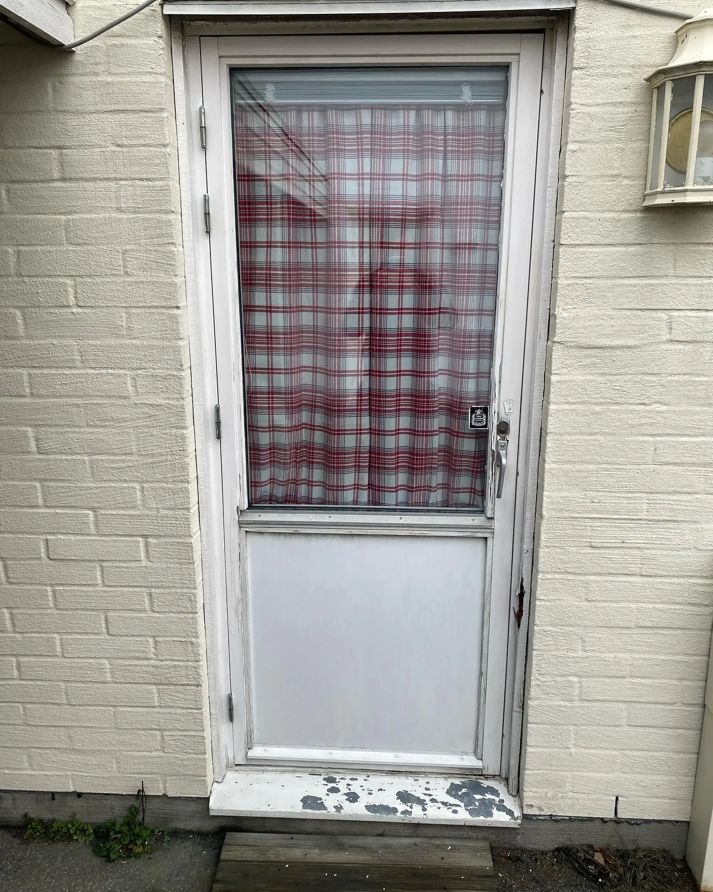 Sliten vit ytterdörr före dörrbyte