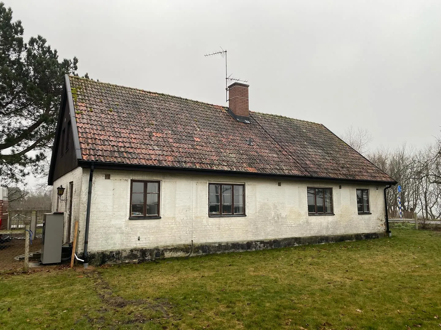 Äldre hus med slitet tegeltak före takbyte